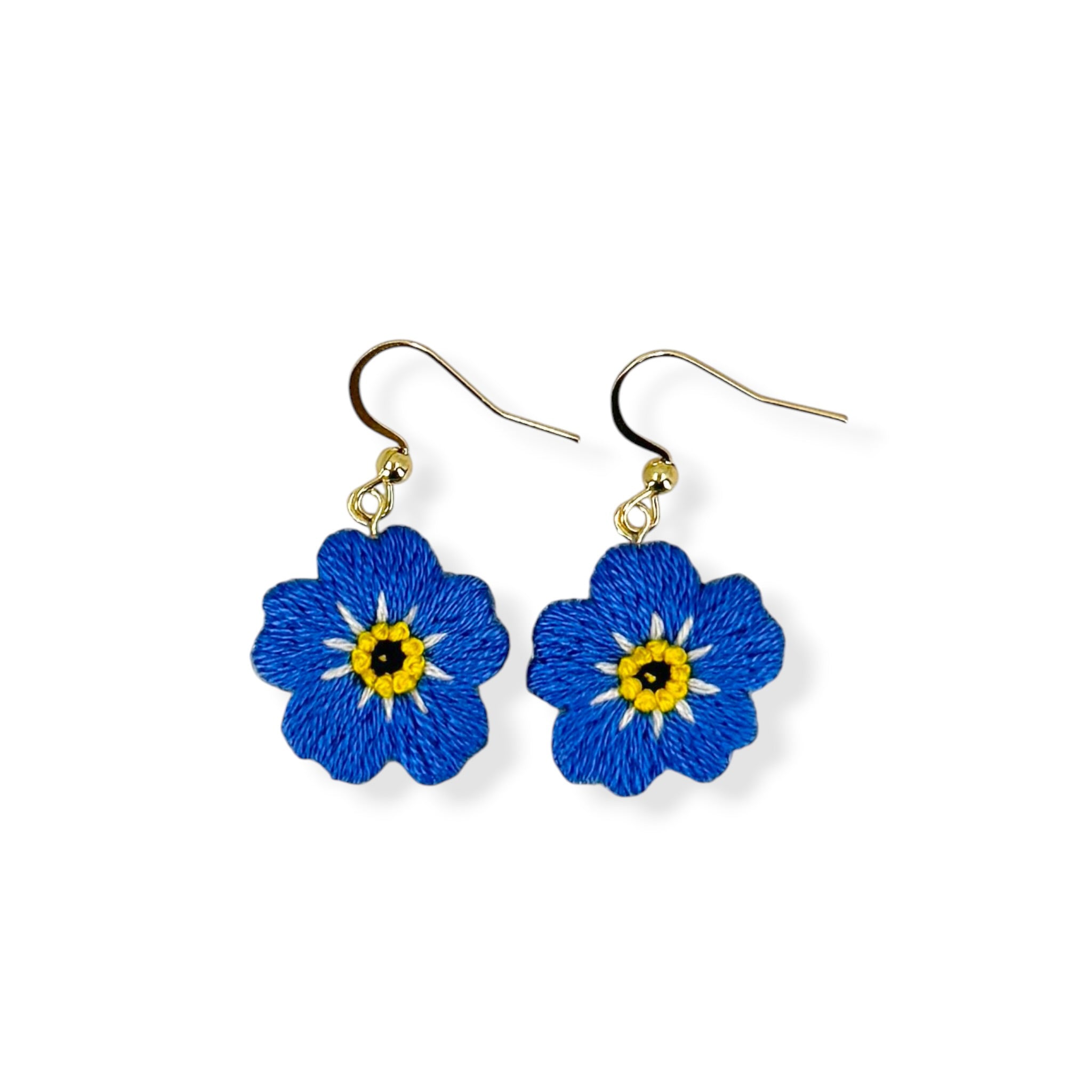 Blue flower-shaped earrings with yellow centers on a white background