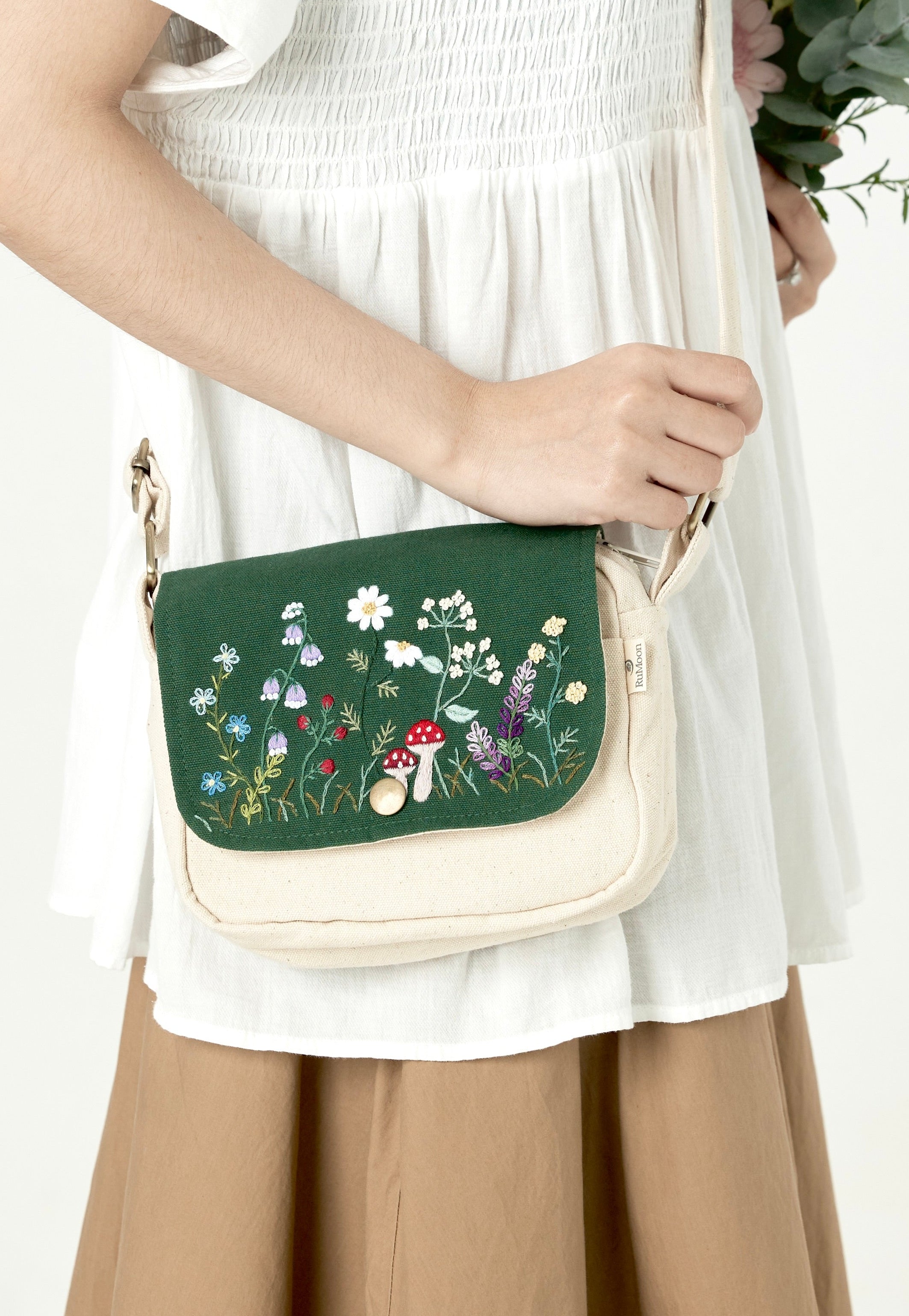 Person holding a floral-patterned handbag with a white background