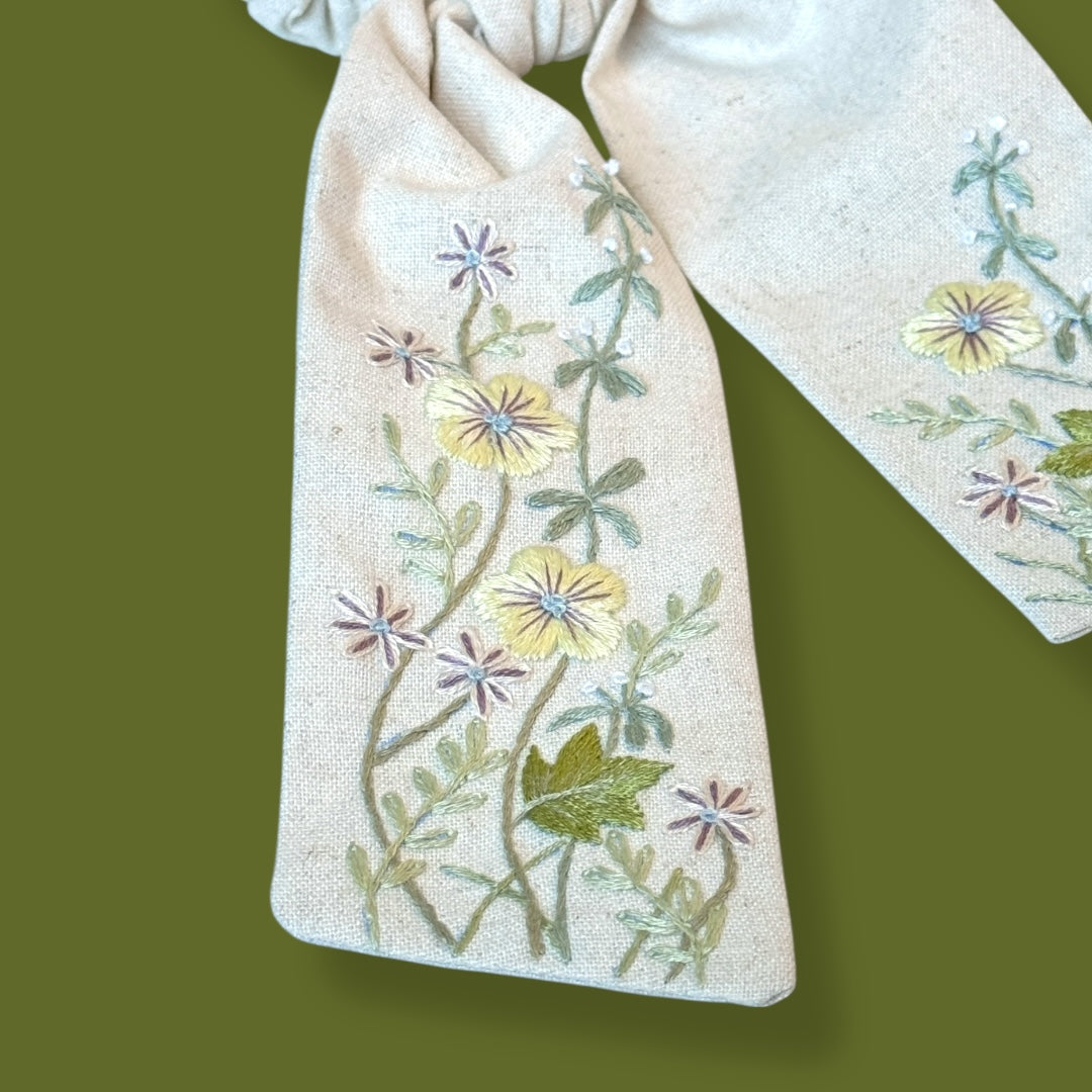 Close-up of floral hand embroidery on linen scrunchie tail, showcasing intricate flower patterns. Perfect cute hair accessory for teenage girls and gifts.