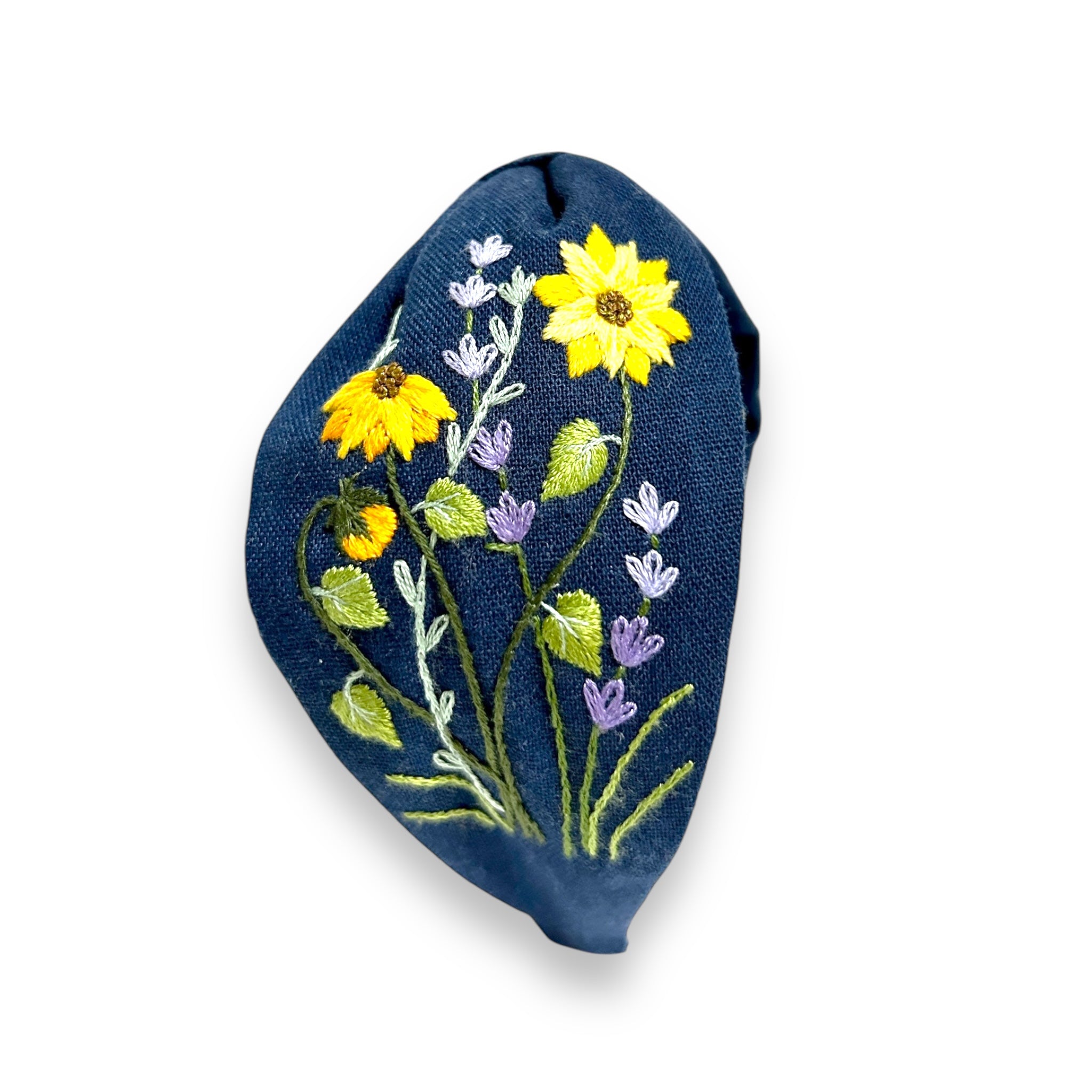 Close-up of Rumoon Handmade Emerald Field Blossom Embroidered Linen Headband with detailed wildflower stitching on navy linen.